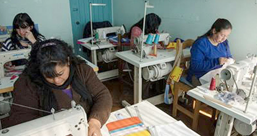 mujeres realizando costura en bolsas de tnt